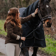 Woman walking a horse on a rural dirt path with cross section head collar and lead rope
